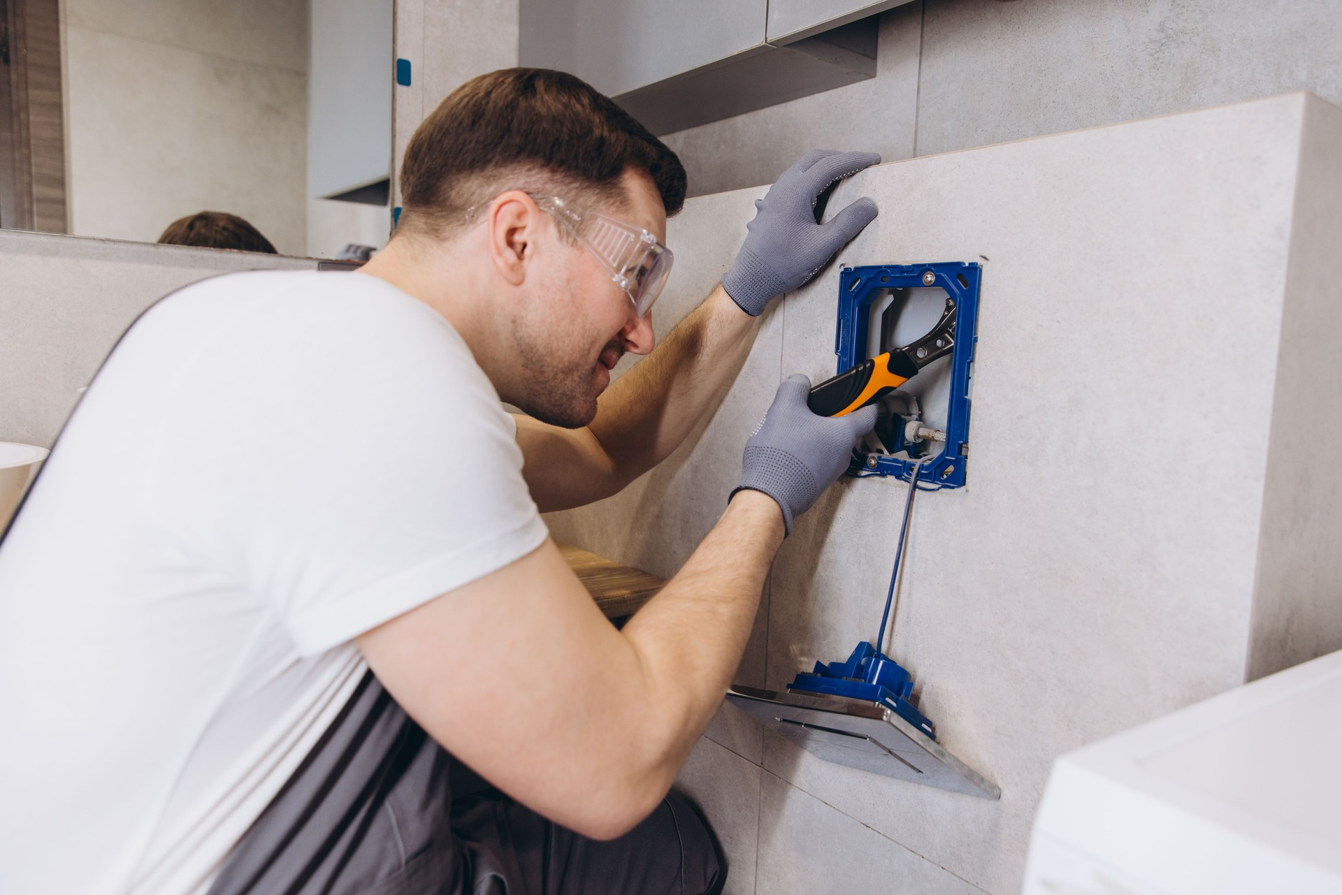 Plumber Installing Shower Faucet in Modern Bathroom